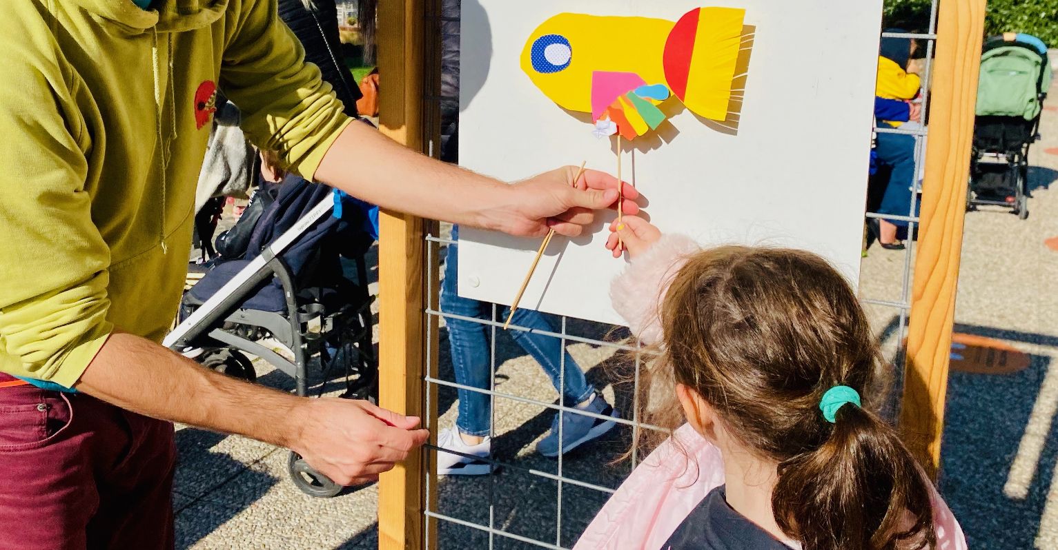 Una bambina appende il suo disegno su una bacheca all'esterno del museo