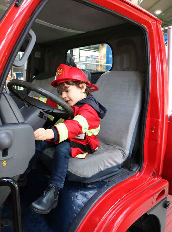 Bambino gioca nel camion dei pompieri