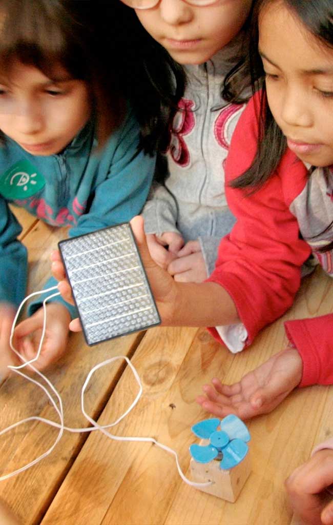 Bambine attivano una piccola elica grazie ad un pannello fotovoltaico
