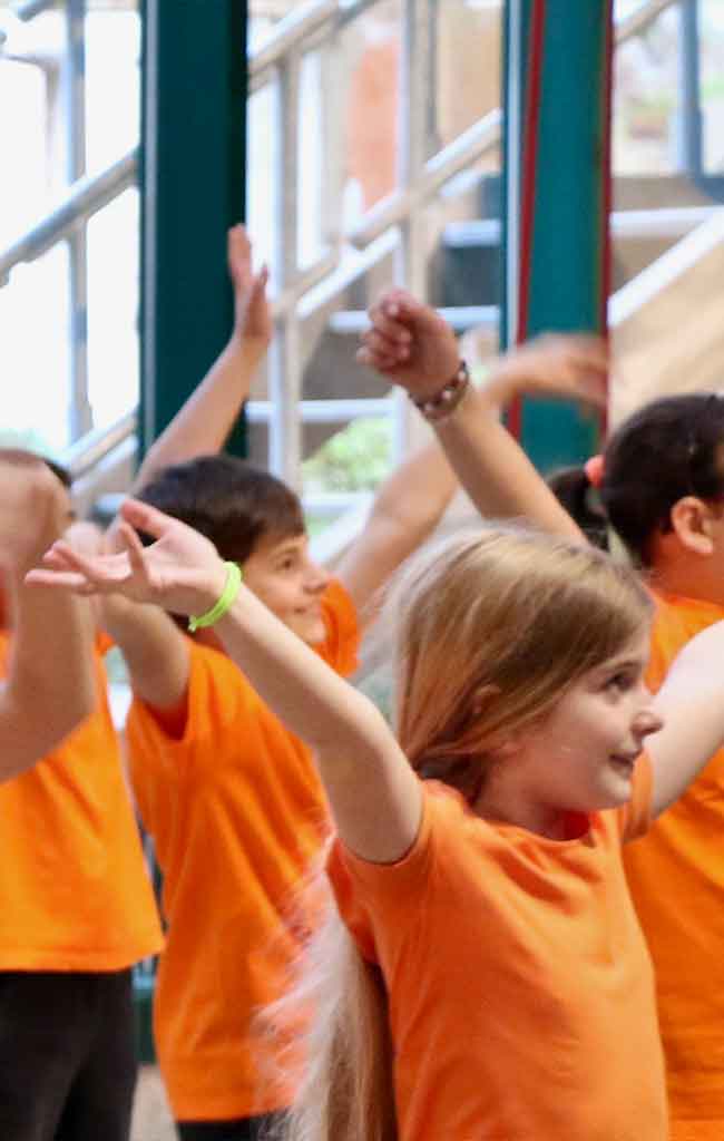 Bambini danzano con la maglia arancio